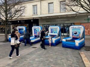 Jeux gonflables de tir installés dans une rue commerçante.