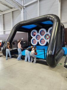 Jeunes jouant au stand de tir gonflable intérieur