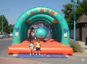 Enfants jouant sur un château gonflable baleine coloré