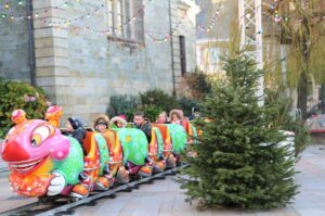 Enfants souriants dans un manège chenille coloré festif.